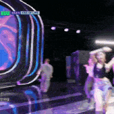 a group of people are dancing on a stage with the words kiss of life on the screen