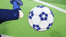 a soccer player kicks a ball with the letter l on his jersey