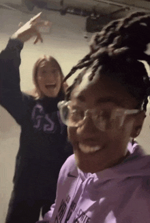 a girl wearing glasses and a purple sweatshirt that says gs