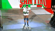a wrestler is walking on a stage with the word rtb written on the bottom