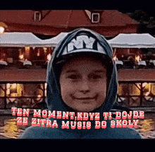 a young boy wearing a ny hat and hoodie