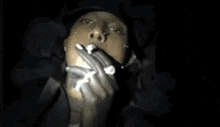 a close up of a person smoking a cigarette with a light coming out of their mouth .