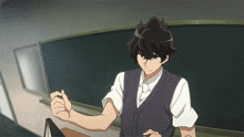 a man standing in front of a blackboard with his fist in the air