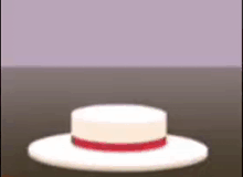 a white hat with a red ribbon around the brim is sitting on a table .