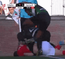a man is laying on top of another man during a soccer game