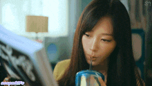 a woman drinking through a straw while reading a magazine with the word negative written below her