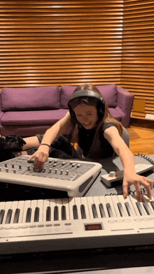 a young girl wearing headphones plays a keyboard