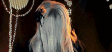 the back of a woman 's head with long white hair and a black hair clip .
