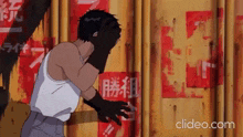 a man is covering his face in front of a wall with chinese writing