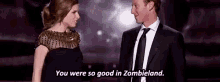 a man and a woman are standing next to each other and the woman says `` you were so good in zombieland '' .