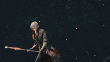 a man is standing in front of a fire and holding a sword .