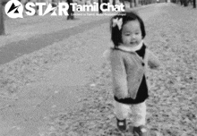 a black and white photo of a little girl with a star tamil chat logo