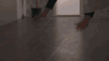 a person is standing on a wooden floor with their hands on the floor .