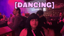 a woman is dancing in front of a sign that says dancing on it