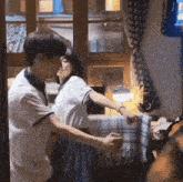 a man and woman are standing next to each other in a room holding hands .