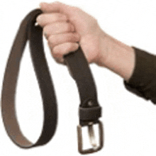 a person 's hand is holding a brown belt with a silver buckle .
