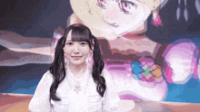 a girl with pigtails is smiling in front of a picture of a girl