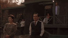 a group of people standing in front of a house with a sign that says ' motel '
