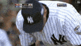a new york yankees baseball player looks down at something