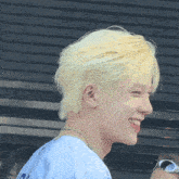 a young man with blonde hair is wearing a blue shirt that says ' i 'm a ' on it