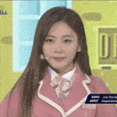 a girl in a pink suit is standing in front of a sign that says song artist dreamcatcher