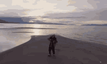 a person standing on a sandy beach with a lake in the background