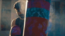 a boxer is hitting a punching bag in a gym .