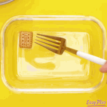 a bag of frosting is being poured into a glass dish