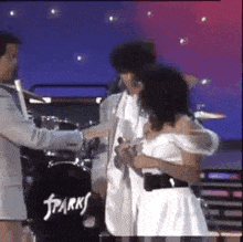 a man and a woman are hugging on a stage .