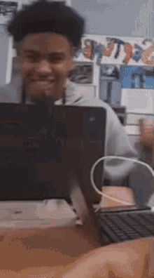 a young man is smiling while using a dell laptop computer