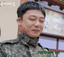 a man in a military uniform is smiling in front of a painting