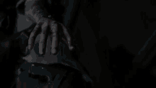 a close up of a person 's hand holding a gun in the dark .