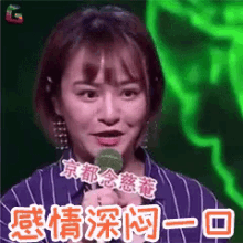 a woman in a striped shirt is holding a microphone and making a funny face .
