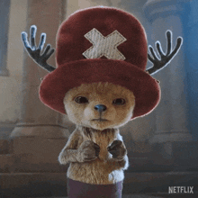 a stuffed animal wearing a red hat with an x on it is from netflix