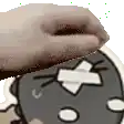 a close up of a person 's hand holding a donut over a cartoon face .