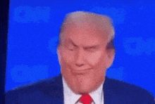 a close up of donald trump 's face against a blue background