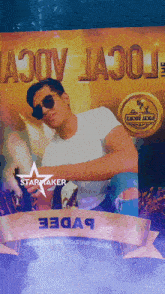 a man wearing sunglasses is standing in front of a starmaker sign