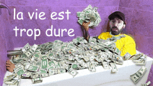 a man is laying in a bathtub filled with money with the words la vie est trop dure written above him