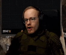 a man wearing headphones is sitting in a chair and making a funny face .
