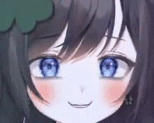 a close up of a girl 's face with blue eyes and a smile .