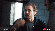 a man with a beard is talking to another man with a nbc logo in the corner