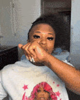 a woman wearing a white t-shirt with a picture of a woman with pink hair