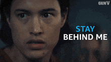 a close up of a man with the words stay behind me behind him