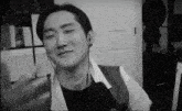 a black and white photo of a man wearing headphones and making a face .