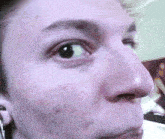 a close up of a person 's face with a purple eye