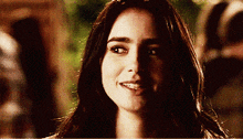 a woman with long dark hair smiles for the camera