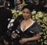 a woman in a striped dress is standing in front of a crowd of people .