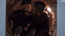 a man and a woman are sitting in a cave and kissing