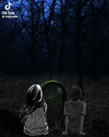 a girl and a boy are sitting next to a grave in the woods