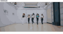 a group of women are dancing in a dance studio with the word wine on the wall behind them